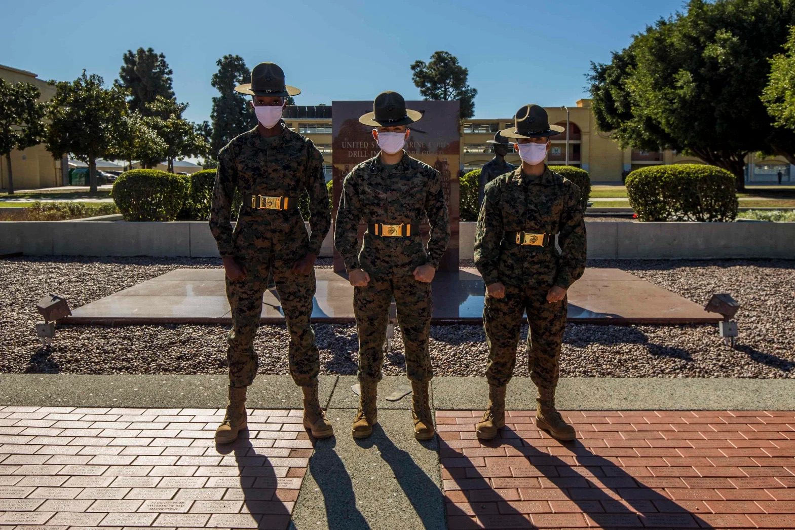 Three marines lined up with shiny belts