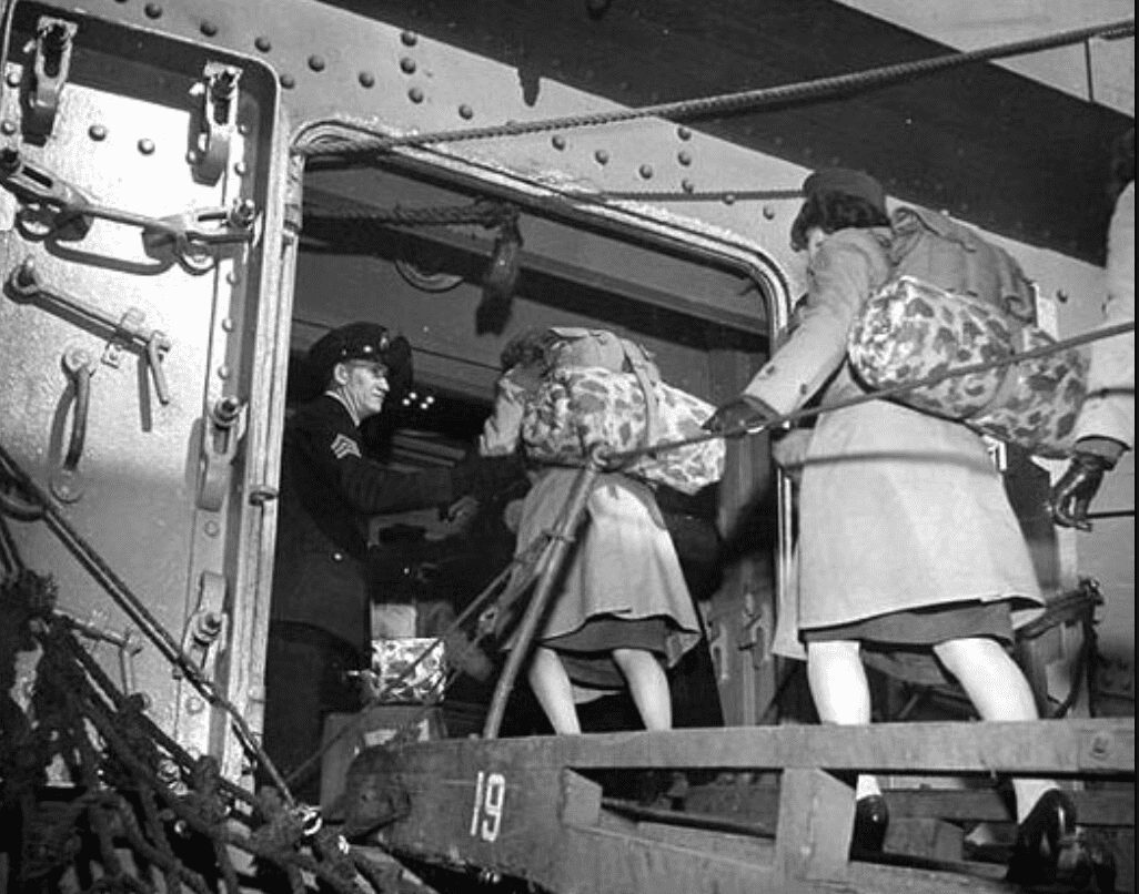 black and white photo of female marines with backpacks on a ship