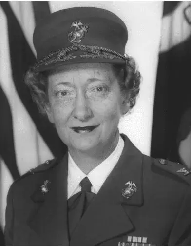 black and white photo of marine wearing cap with flags in background